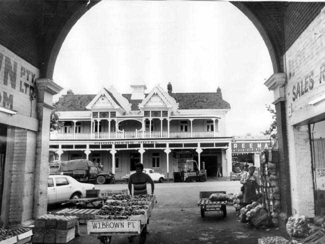 Trevor Alfred, of W.J. Brown Wholesale Fruit and Vegetables, pushes a barrow 
loaded with fresh fruit at the East end Market in 1976.
